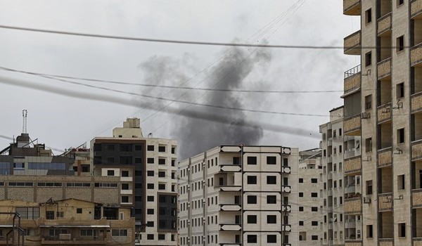 지난달 30일(현지 시간) 시리아 수도 다마스쿠스 남부 사나야 마을에서 시리아 보안군 작전 중 건물 뒤에서 연기가 피어오르고 있다. [ 사진= 뉴시스 ]