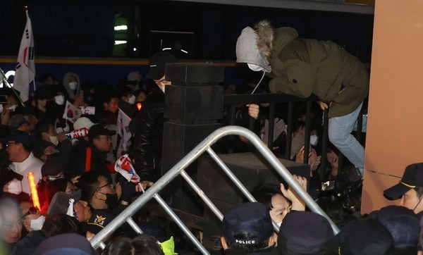내란 우두머리 혐의로 체포된 윤석열 대통령의 구속 전 피의자 심문(영장실질심사)가 열린 18일 서울 마포구 서울서부지방법원에서 시위자들이 담을 넘고 있다.  [ 사진= 뉴시스 ]