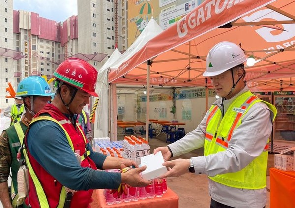 현대건설 CSO 황준하 전무가 지난 21일 근로자에게 수분 보충과 탈수 예방을 위한 이온음료와 쿨링스프레이를 직접 전달하고, 근로자들의 노고를 격려하는 모습.  [사진=현대건설]