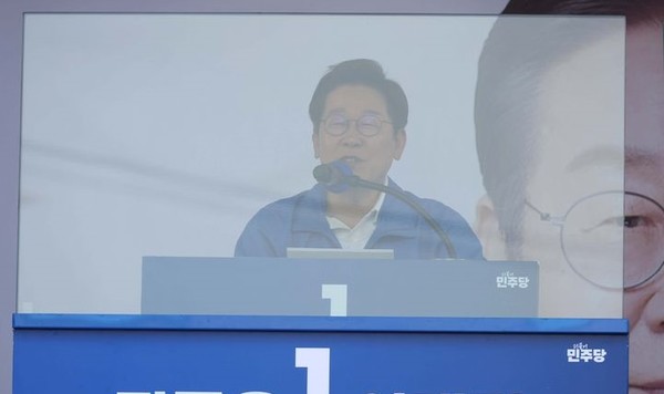 이재명 더불어민주당 대선 후보가 25일 충남 당진시 당진전통시장 입구에서 열린 유세에서 방탄유리 뒤에 서 있다. [사진=뉴시스]