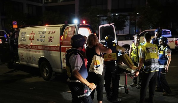 6월13일 이스라엘 텔아비브에서 구급대원들이 이란이 발사한 미사일에 맞은 건물에서 부상자를 대피시키고 있다.[사진=뉴시스]