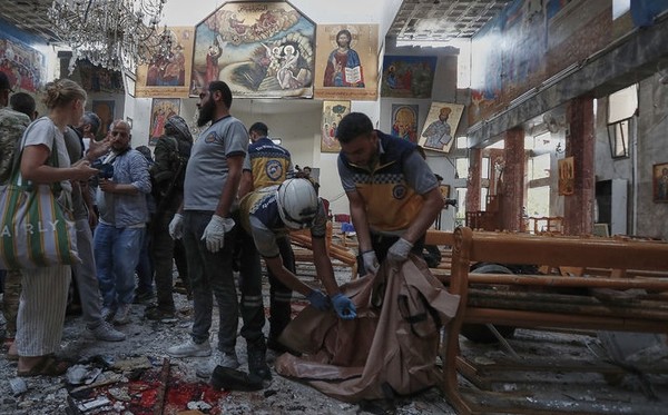 시리아 민방위 대원들이 22일 다마스쿠스 외곽 드웨일라 지구에 있는 그리스정교 교회에서 발생한 자폭테러 사건 직후 현장에 출동해 시신을 수습하고 잔해물을 치우고 있다. [사진=뉴시스]