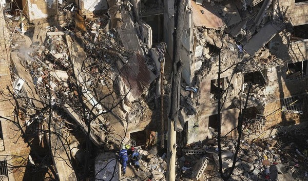 23일 우크라이나 키이우에서 소방관들이 러시아의 공격으로 파괴된 아파트 건물을 수색하고 있다. [사진=뉴시스]