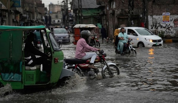 파키스탄의 중부 라호르 시내에서 29일(현지시간) 장마철을 맞아 쏟아진 폭우로 침수된 도로를 운전자들이 조심스럽게 통과하고 있다. 