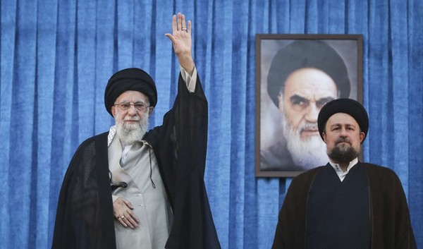 이란 최고 지도자 알리 하메네이가 지난 4일 테헤란에서 열린 이란 이슬람혁명 창시자 루홀라 호메이니의 사망 36주년 기념식 참석을 위해 도착하면서 호메이니의 손자 하산 호메이니(오른쪽)가 지켜보는 가운데 군중들에게 손을 흔들고 있다. [사진=뉴시스]