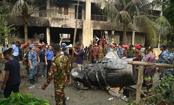 21일(현지 시간) 방글라데시 다카에서 방글라데시 공군 훈련기가 한 학교에 추락한 뒤 경찰과 소방관들이 현장을 수습하고 있다. [사진=뉴시스]