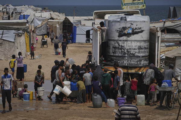 13일(현지 시간) 가자지구 칸유니스 난민촌에서 폭염 속 팔레스타인 피란민들이 급수 차량에서 물을 받고 있다. [사진=뉴시스]