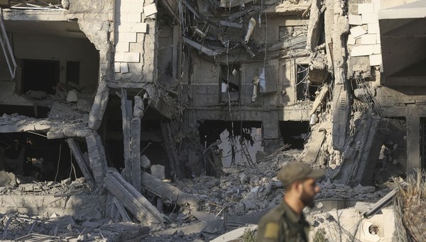 시리아 다마스쿠스에서 7월 16일 한 군인이 이스라엘의 공습으로 파손된 시리아 국방부 청사 앞을 지나가고 있다. 시리아와 이스라엘은 미국의 중재로 8월 19일 외교관들이 만나서 시리아 남부의 영토보존과 평화유지에 대해 논의했다고 시리아 국영 SANA통신이 보도했다. [사진=뉴시스]