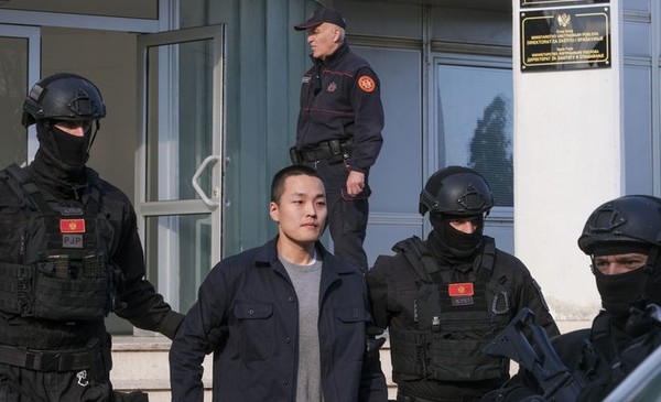 가상화폐 '테라·루나' 사태의 핵심 인물 권도형 테라폼랩스 대표가 지난해 3월 23일(현지 시간) 몬테네그로 포드고리차의 경찰청에서 조사를 받은 후 경찰관들에게 이끌려 나오고 있다. 권씨는 11일 미국 뉴욕 남부연방지방법원에서 사기 혐의로 징역 15년형을 선고 받았다. [사진=뉴시스]