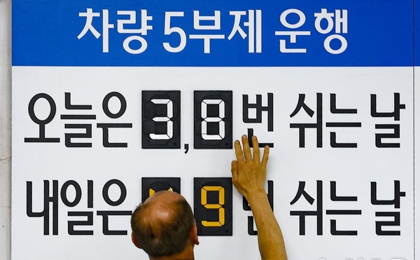 공공부문 승용차 5부제 의무화 첫날이자 금융업계도 차량 5부제 운행에 동참한 가운데 25일 오전 서울 중구 우리은행 본점 주차장에서 한 주차 안내원이 숫자를 조정하고 있다. [사진=뉴시스]