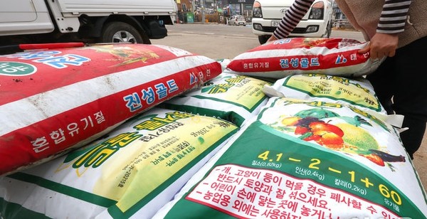 중동사태의 여파로 요소와 유황 등의 원자재 수급 불안으로 화학 비료 가격이 급등하는 가운데 11일 오후 인천 강화군의 한 농자재 상점에서 상인이 화학비료를 정리하고 있다. [사진=뉴시스]